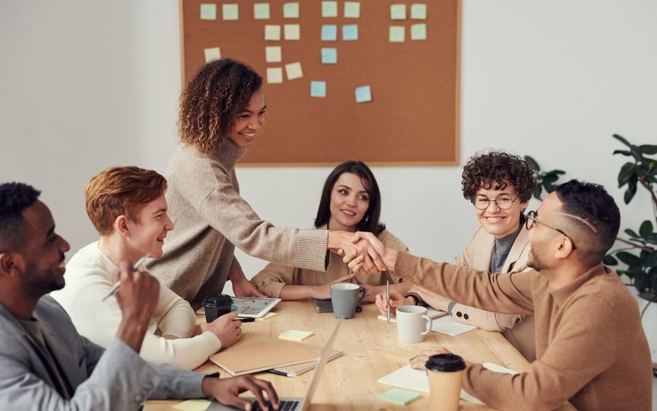 Professionals sharing a conversation and shaking hands at a meeting
